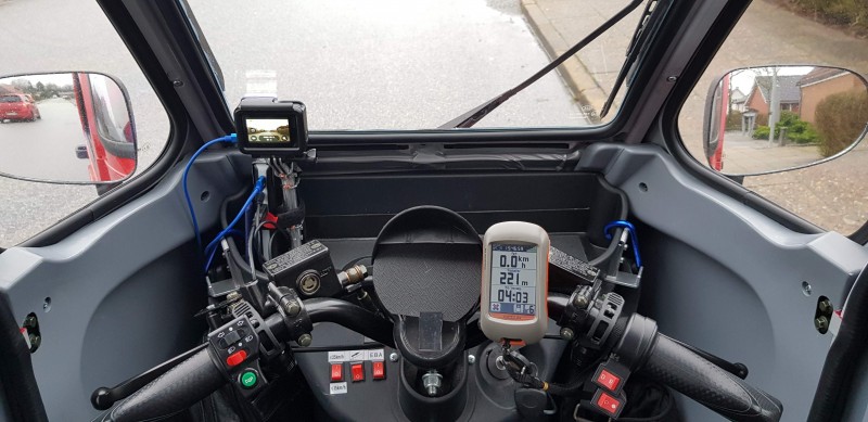 Førerplads med powerbank, GoPro, afdækket speedometer og lille vandre GPS.